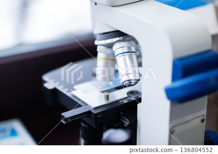 High detail scene showing lab technician analyzing sample through advanced microscopy tools High detail scene showing lab technician analyzing sample through advanced microscopy tools 136804552