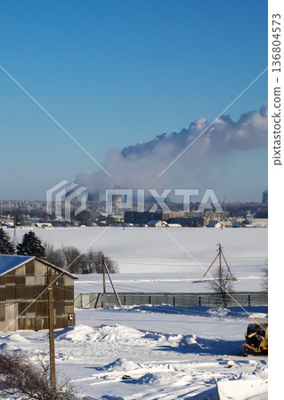 Quiet morning scene blending peaceful farm environment with distant pollution plumes in winter 136804573