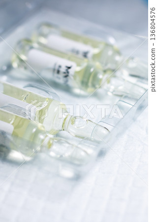 Detailed view of sterile ampoules arranged on tray with faint labels for medical testing Detailed view of sterile ampoules arranged on tray with faint labels for medical testing 136804576