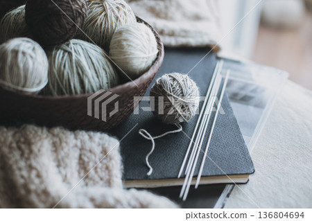 Balls of wool yarn and needles for hand knitting in a basket. Concept for handmade. Balls of wool yarn and needles for hand knitting in a basket. Concept for handmade. 136804694