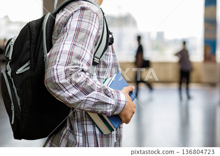 Student with books in hall Student with books in hall 136804723