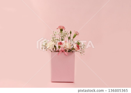 Carnations in a pink box, abstract spring floral background. Creative modern bouquet, minimal holiday concept. Greeting card for Women's Day or Mother's Day, happy birthday, wedding, gift for loved Carnations in a pink box, abstract spring floral background. Creative modern bouquet, minimal holiday concept. Greeting card for Women's Day or Mother's Day, happy birthday, wedding, gift for loved 136805365