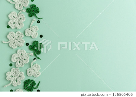 Crocheted Four Leaf Clovers with Sequins. Saint Patricks Day Decorative Background Crocheted Four Leaf Clovers with Sequins. Saint Patricks Day Decorative Background 136805406