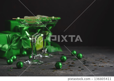 Green Cocktails with Lime, Gifts and Confetti. Festive St. Patricks Day Celebration Still Life Green Cocktails with Lime, Gifts and Confetti. Festive St. Patricks Day Celebration Still Life 136805411