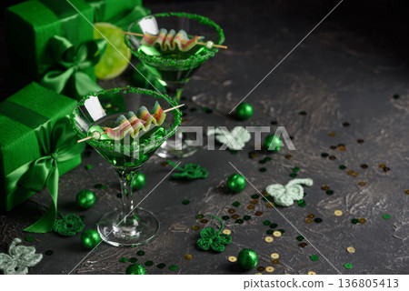 Green Cocktails with Rainbow Candy, shamrocks, Gifts and Confetti. Festive St. Patricks Day Celebration Still Life 136805413