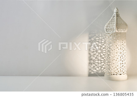 White ramadan lantern casting islamic pattern shadow on wall 136805435