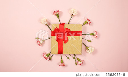 Carnations with a gift on a pink table, abstract spring floral background. Creative modern bouquet, minimal holiday concept. Greeting card for Women's Day or Mother's Day, Carnations with a gift on a pink table, abstract spring floral background. Creative modern bouquet, minimal holiday concept. Greeting card for Women's Day or Mother's Day, 136805546