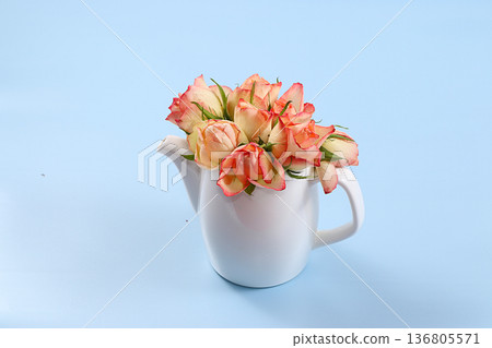 Kettle with roses on a blue background. Wishes good morning and have a nice day, minimal concept of holiday and spring. Greeting card, spring banner for the screen, happy birthday, wedding, gift for 136805571