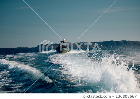 the coast of the Barents Sea, pleasure boats in the sea, the rocky shore with colourful arctic carpet of moss, yagel, Tundra at autumn the coast of the Barents Sea, pleasure boats in the sea, the rocky shore with colourful arctic carpet of moss, yagel, Tundra at autumn 136805667