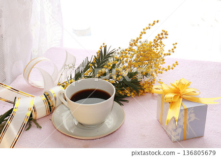 A cup of coffee and spring flowers mimosa on a light background, wishes of good morning and happy women's day 136805679