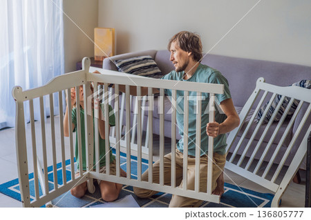 Father and older brother assembling a baby crib at home, preparing for a newborn arrival. Warm family moment full of care and anticipation. Parenthood, sibling bond and home preparation concept Father and older brother assembling a baby crib at home, preparing for a newborn arrival. Warm family moment full of care and anticipation. Parenthood, sibling bond and home preparation concept 136805777