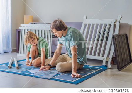 Father and older brother assembling a baby crib at home, preparing for a newborn arrival. Warm family moment full of care and anticipation. Parenthood, sibling bond and home preparation concept 136805778