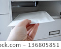 Postbox for letters in modern apartment house. The letter in metal white mailbox in lobby of building. 136805851