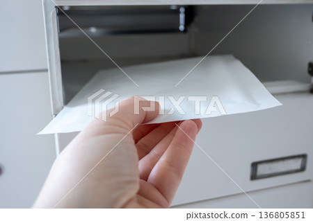 Postbox for letters in modern apartment house. The letter in metal white mailbox in lobby of building. Postbox for letters in modern apartment house. The letter in metal white mailbox in lobby of building. 136805851