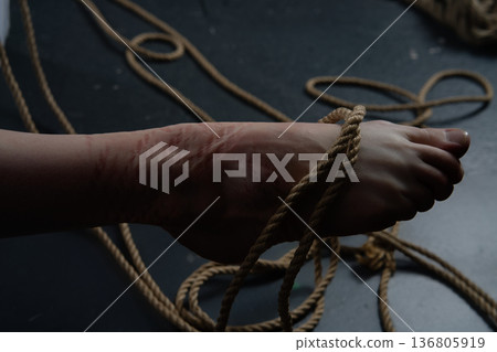 Shibari art shown through ropes tied on a woman's foot in a simple space Shibari art shown through ropes tied on a woman's foot in a simple space 136805919