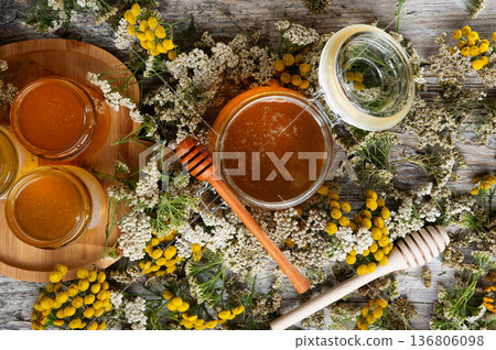 fresh natual different  honey in glass jars with wooden  honey spoons around herb flowers. flat lay 136806098
