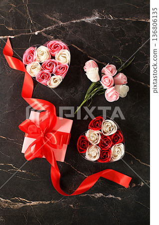 Beautiful pink flowers in a box with a heart. a gift and a bouquet on a marble black background. Abstract floral arrangement, spring background or banner, holiday concept. Mother's Day card, wedding, Beautiful pink flowers in a box with a heart. a gift and a bouquet on a marble black background. Abstract floral arrangement, spring background or banner, holiday concept. Mother's Day card, wedding, 136806135
