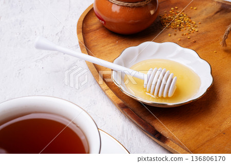 linden honey with cup of tea at wooden tray at white table. close up 136806170