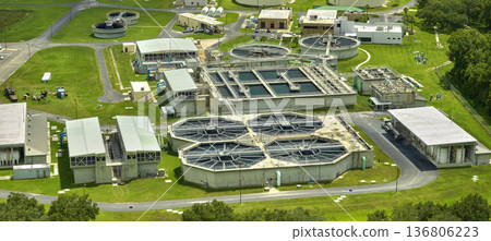 Aerial view of modern water cleaning facility at urban wastewater treatment plant. Purification process of removing undesirable chemicals, suspended solids and gases from contaminated liquid Aerial view of modern water cleaning facility at urban wastewater treatment plant. Purification process of removing undesirable chemicals, suspended solids and gases from contaminated liquid 136806223