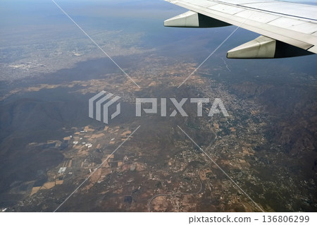 View through airplane window of commercial jet plane wing flying high in the sky. Air travelling concept 136806299