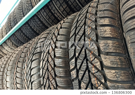Many black rubber car tires on store shelf for sale. Many black rubber car tires on store shelf for sale. 136806300