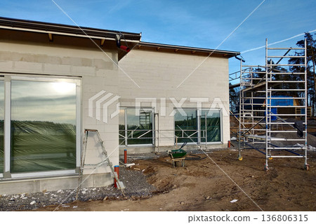Facade of building made from white blocks with big windows under construction works. 136806315