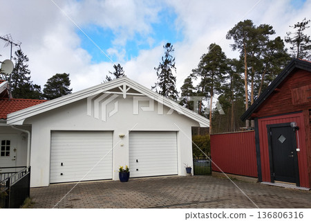 White new garage for two cars and wooden barn on private house yard. 136806316
