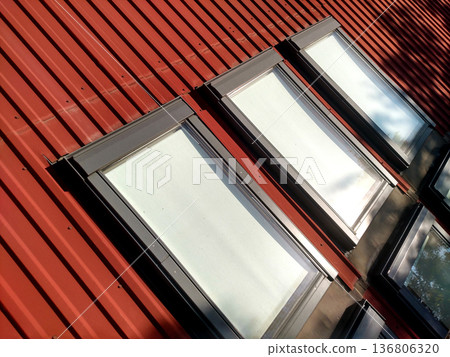 Red tiled house roof with attic windows. Roofing construction, window installation, modern architecture concept. 136806320