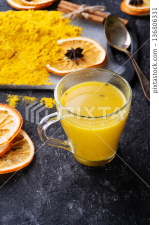 Curcuma (turmeric) spice , curcuma cocktail served with dry oranges and Curcuma powder at black table. 136806331