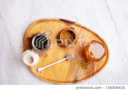 linden honey with perga at wooden tray at white table. copy space. flat lay linden honey with perga at wooden tray at white table. copy space. flat lay 136806416