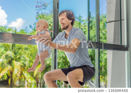 Father exercising with his small baby at home, active parenting and healthy lifestyle. Strong family bond, early physical development, modern fatherhood, fitness with children concept. Father exercising with his small baby at home, active parenting and healthy lifestyle. Strong family bond, early physical development, modern fatherhood, fitness with children concept. 136806488