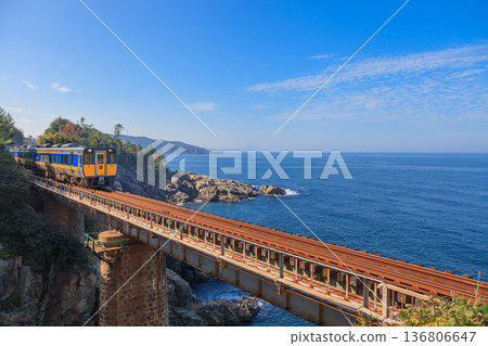 The Aoura Railway Bridge on the San'in Main Line illuminated by the morning sun and the deep blue Sea of Japan 136806647
