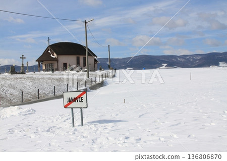 A village road is buried under a mountain of snow after a snowstorm. 136806870