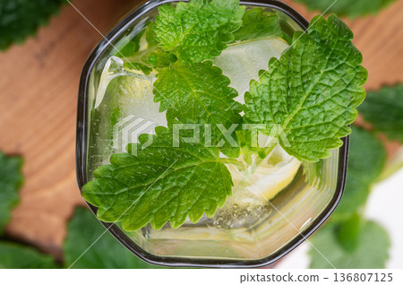 fresh lemonade served in glass with melissa and ice . macro shot. top view fresh lemonade served in glass with melissa and ice . macro shot. top view 136807125