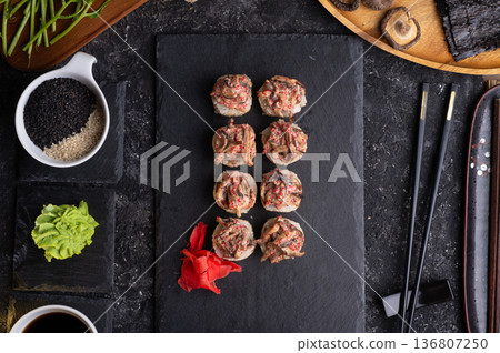 sushi roll with shiitake mushrooms served at black dish with rise at black table. flat lay sushi roll with shiitake mushrooms served at black dish with rise at black table. flat lay 136807250