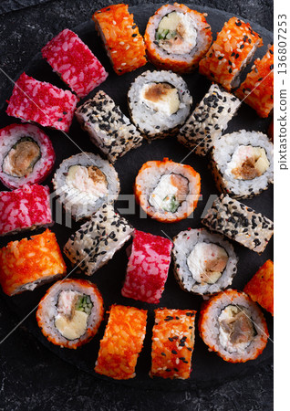 different delicious sushi rolls set with fish beautiful served at black dish  at black table. flat lay. close up 136807253