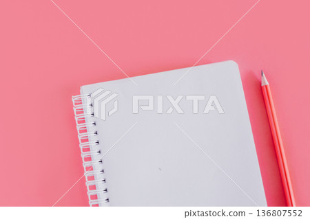 Notebook with a blank page and a pencil on pink background. 136807552