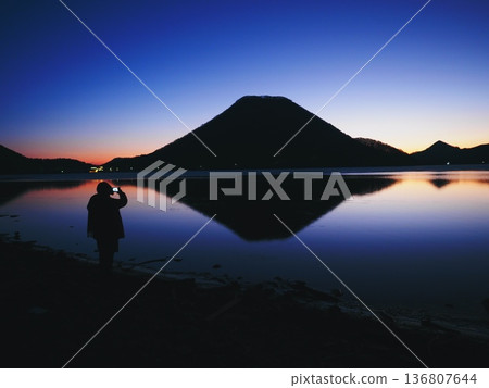 A person standing by a lake at dawn (20260212055327) A person standing by a lake at dawn (20260212055327) 136807644