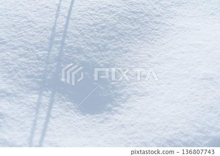 A snowy landscape enveloped in silence, with the contrast of light and shadow created by sunlight. A snowy landscape enveloped in silence, with the contrast of light and shadow created by sunlight. 136807743