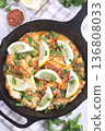 Haddock fish piccata with lemon and capers in cast iron pan, vertical, top view closeup 136808033