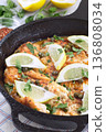 Delicious haddock fish piccata with lemon and capers in cast iron pan, vertical 136808034