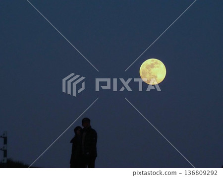 Two people illuminated by the full moon Two people illuminated by the full moon 136809292
