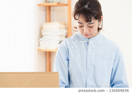 一位女士正在整理不需要的物品。 136809636