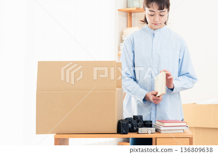 一位女士正在整理不需要的物品。 136809638