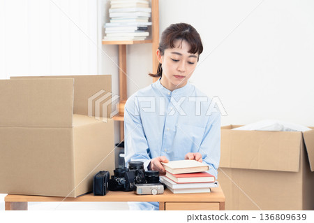 A woman sorting out unnecessary items A woman sorting out unnecessary items 136809639