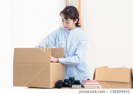 一位女士正在整理不需要的物品。 136809642