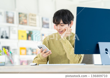 Young designer using smartphone in office 136809710
