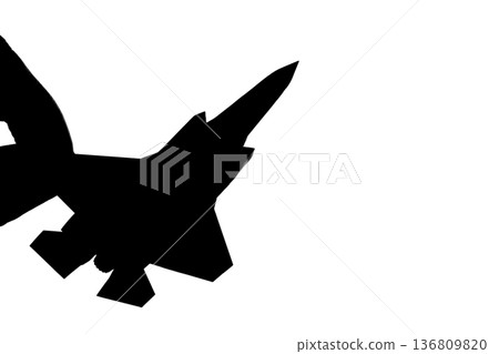 一架噴射戰鬥機的輪廓，被手指夾在中間。 136809820