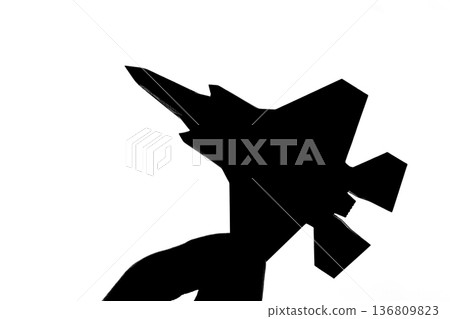 Silhouette of a jet fighter held between fingers 136809823