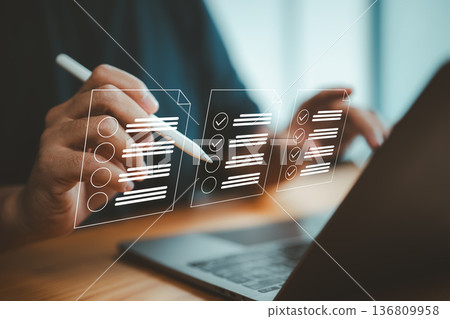 Person Using Digital Checklist Interface with Laptop and Stylus Pen Person Using Digital Checklist Interface with Laptop and Stylus Pen 136809958